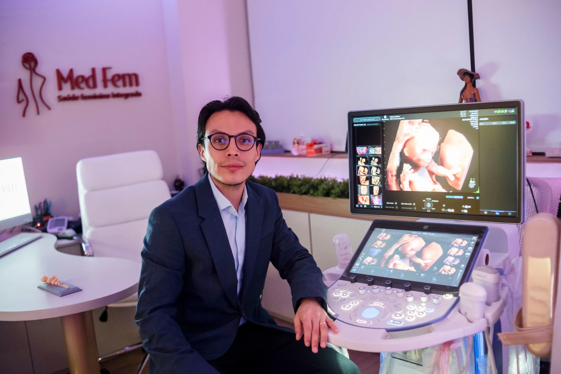 Dr. Héctor Burbano ao lado do aparelho de ultrassonografia com imagem 3D do bebê